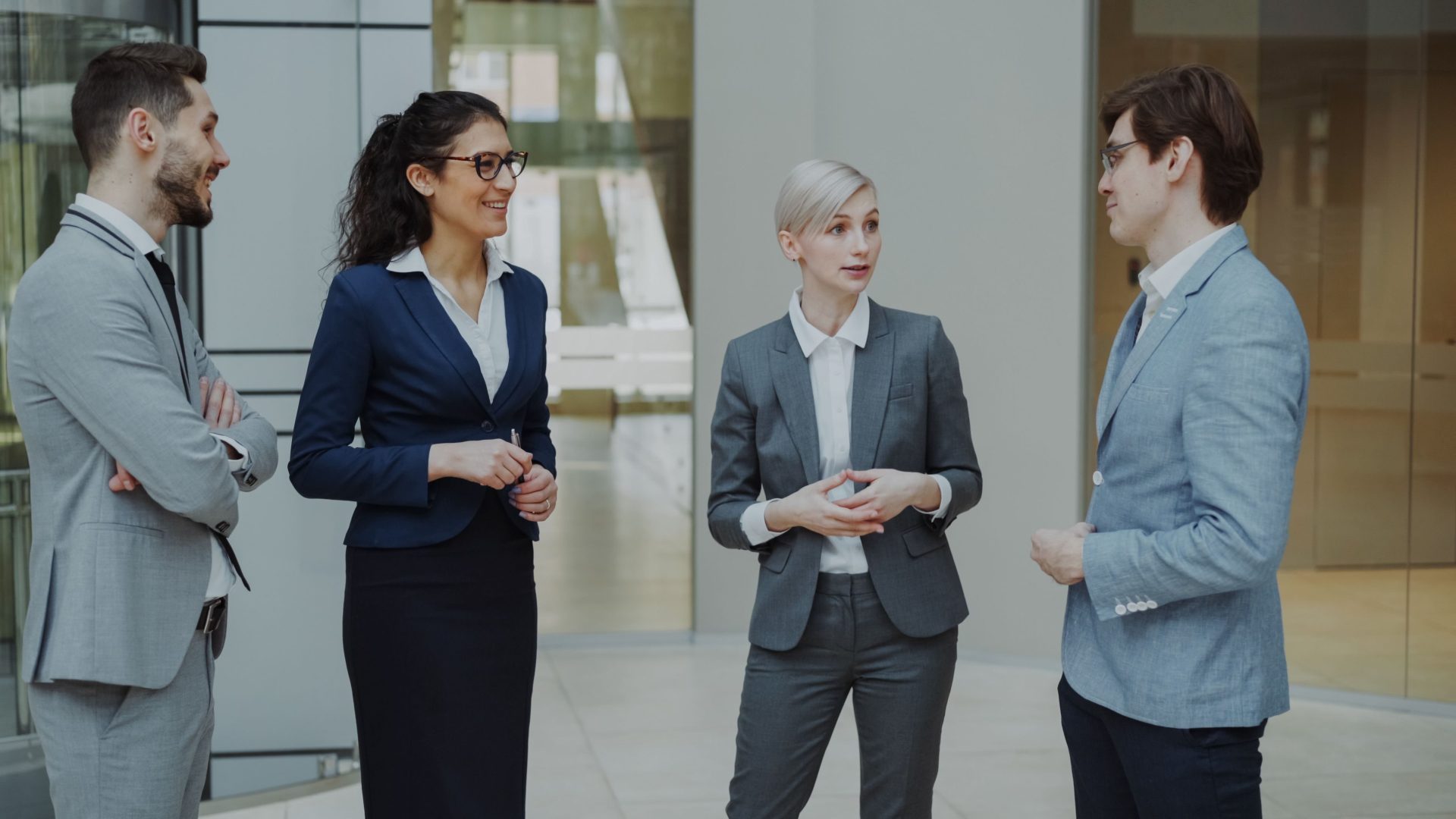 Groupe de professionnels issus d'horizons divers discutant dans un bureau au cadre moderne.