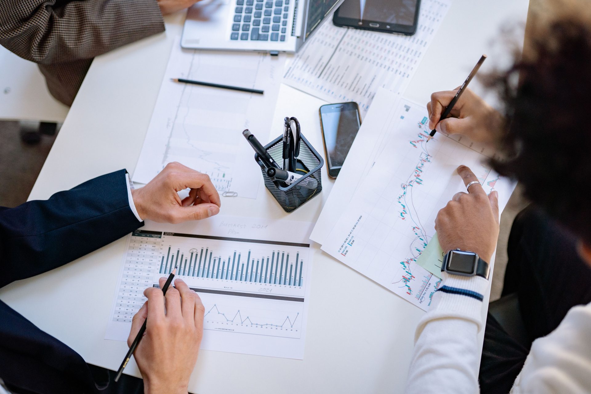 Une équipe d'entreprise analyse des tableaux et des graphiques financiers lors d'une réunion collaborative.