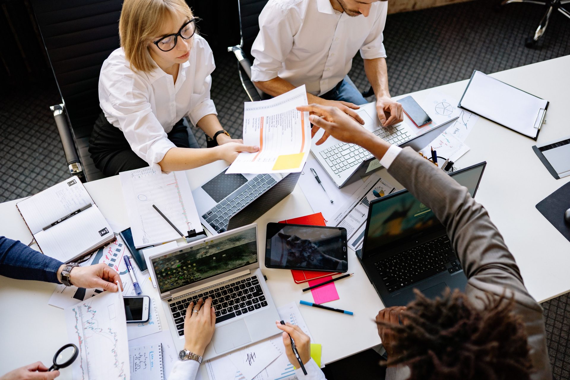 Une équipe diversifiée collaborant dans un bureau moderne avec des ordinateurs portables et des documents.