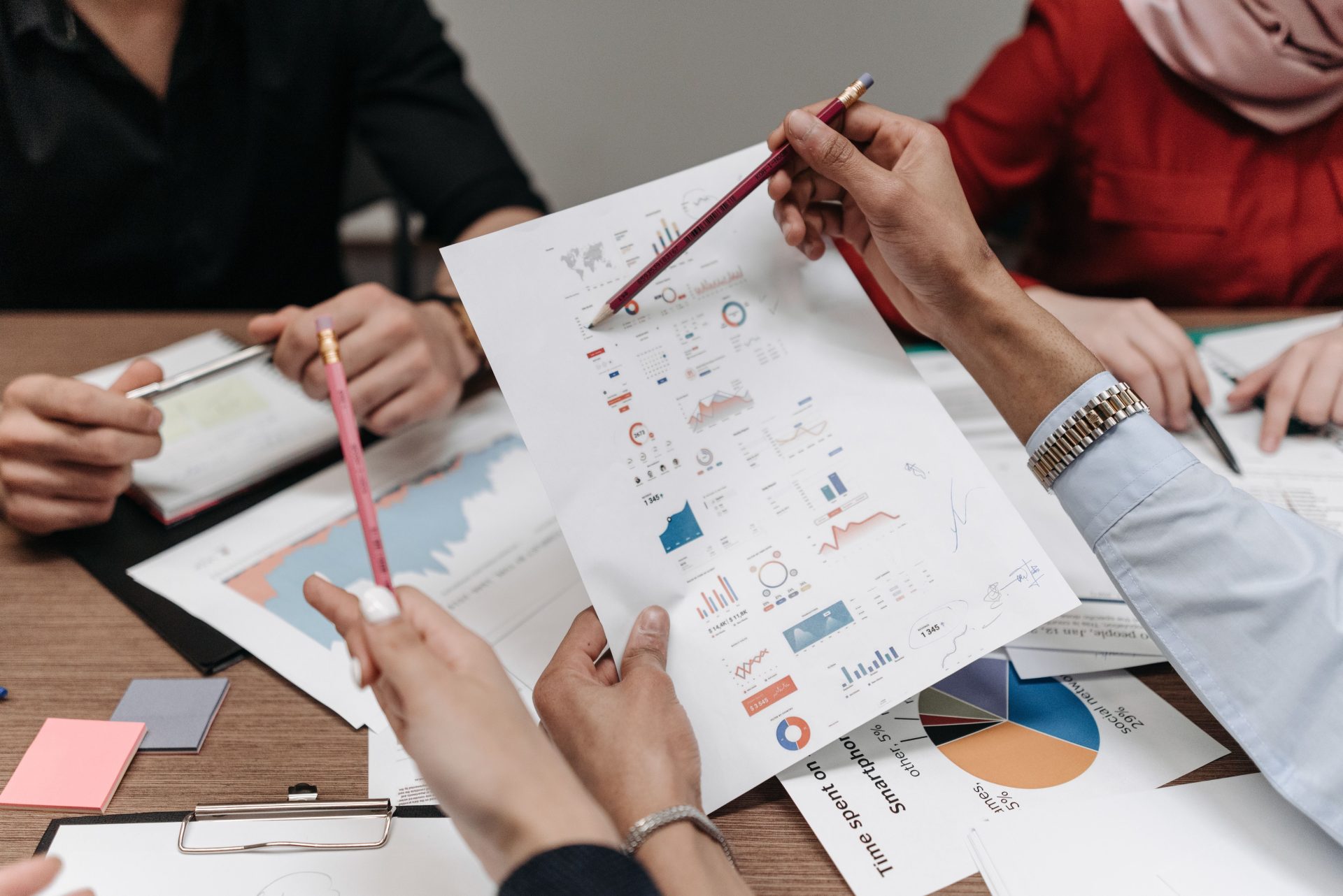Une équipe analyse des rapports et des graphiques d'activité lors d'une réunion collaborative.